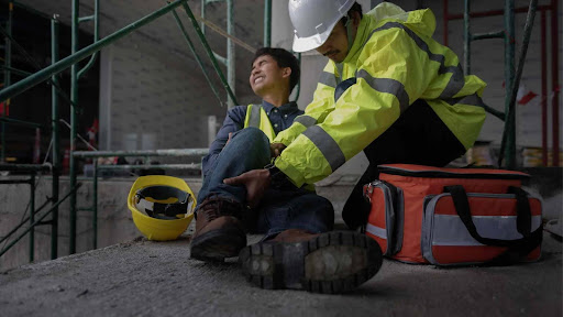 Shows a worker checking the condition of a fellow worker at a construction accident in NJ.